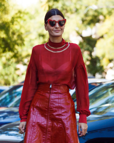 Italian woman wearing a chic red blouse, skirt and sunglasses