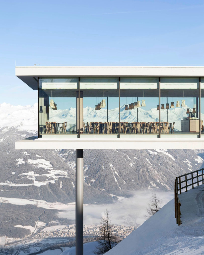 A view of the restaurant AlpiNN, a square, stilt building with panoramic windows in the Dolomites 